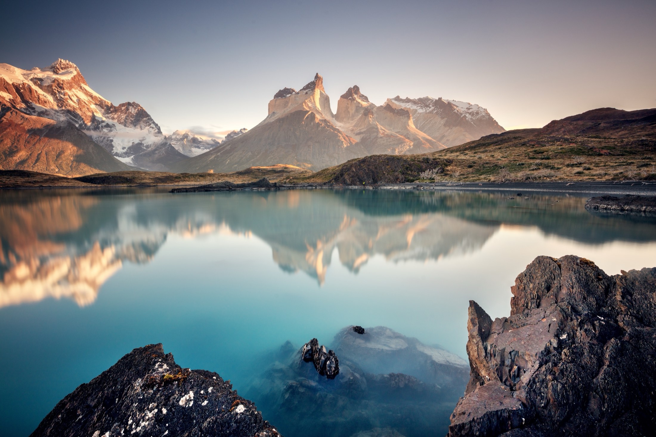 Sunrise over mountain peaks reflected in a still lake
